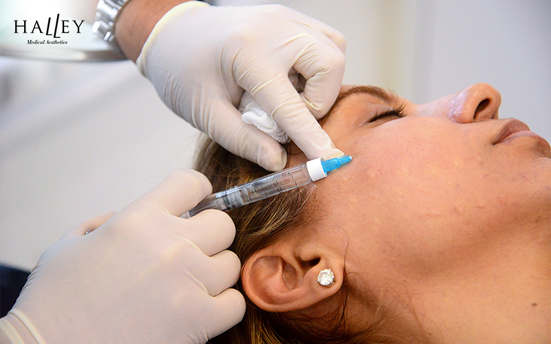Doctor conducting hydrating skin booster treatment on patient face