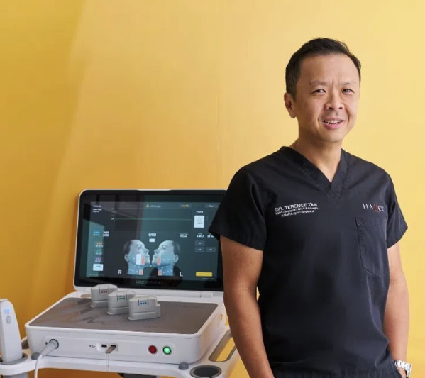 An image of Dr Terrence Tan standing beside utlherapy equipment