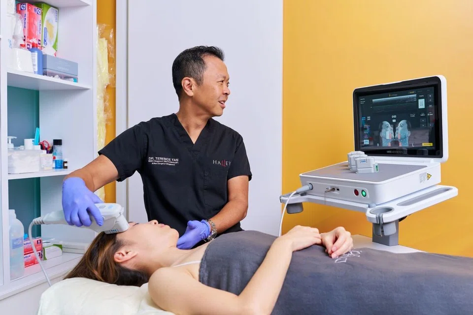 Dr Terrence Tan performing a face treatment on a patient