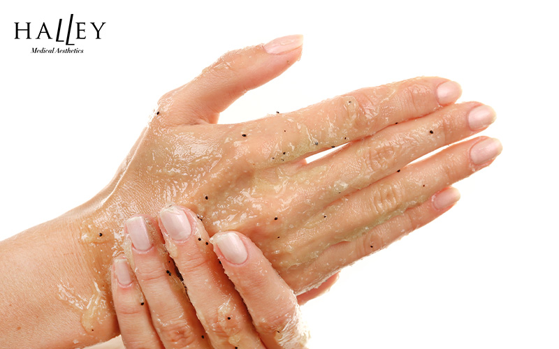 Hands using exfoliating scrub.